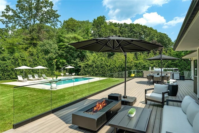 wooden deck with an outdoor living space with a fire pit, an outdoor pool, a lawn, and outdoor dining space