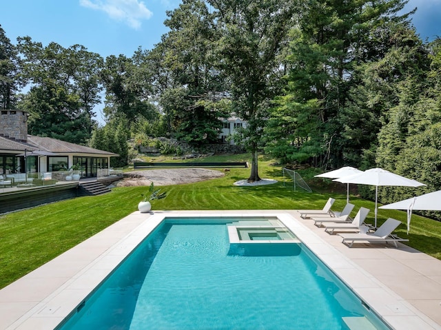 view of pool featuring a pool with connected hot tub, a lawn, and a patio