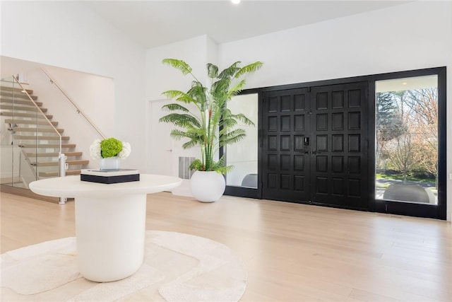 foyer with visible vents, light wood finished floors, and stairs