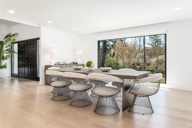 dining room with baseboards, light wood-style flooring, and recessed lighting