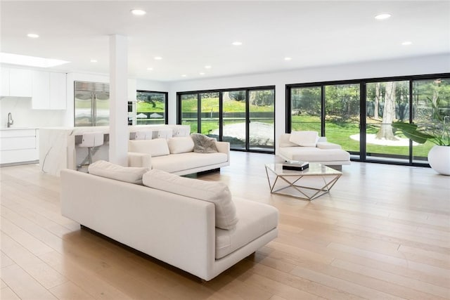 living area with recessed lighting and light wood-style floors