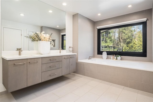 bathroom featuring double vanity, tile patterned flooring, a sink, and a bath