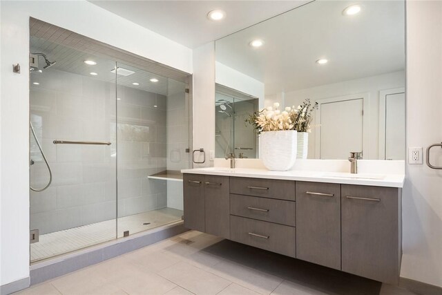 full bath with double vanity, recessed lighting, a sink, and a shower stall