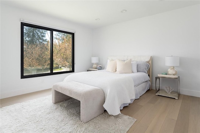 bedroom with light wood-type flooring and baseboards