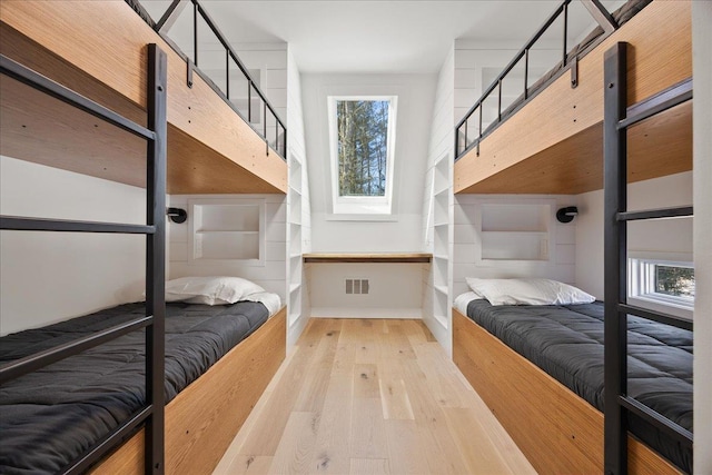 bedroom featuring light wood-type flooring, baseboards, and visible vents