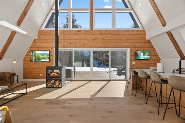 bonus room featuring wood walls, beamed ceiling, and wood finished floors