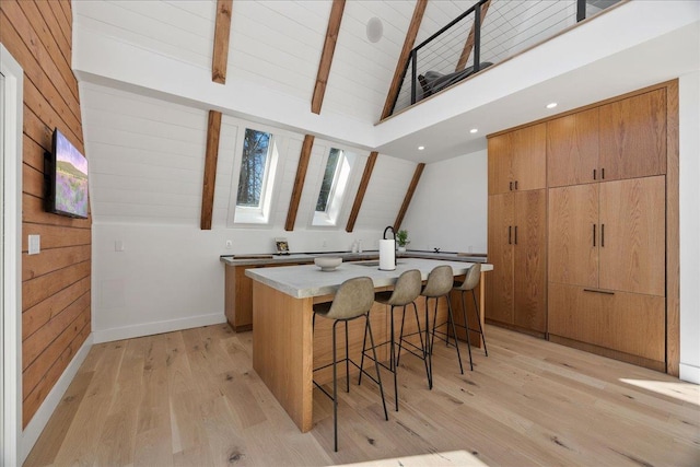 bar featuring light wood finished floors, wood walls, high vaulted ceiling, beamed ceiling, and baseboards