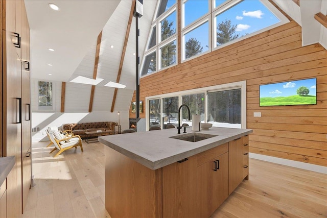 kitchen with dark countertops, a sink, wooden walls, and modern cabinets