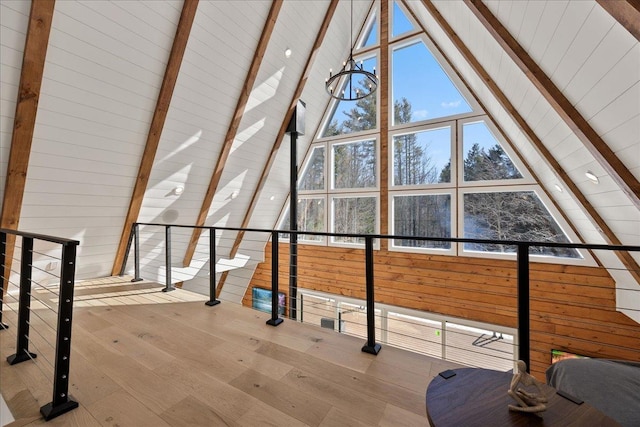 additional living space featuring high vaulted ceiling, light wood-style floors, and beamed ceiling