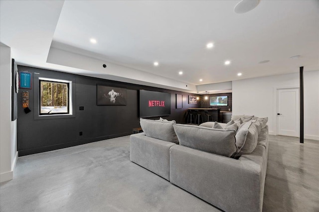 living area with baseboards, concrete flooring, and recessed lighting