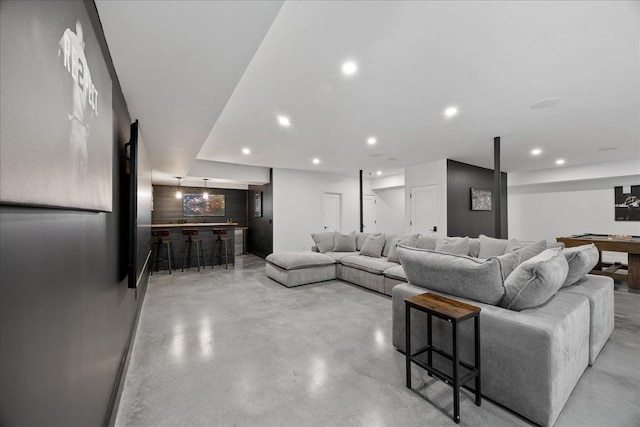 living area with a bar, concrete floors, and recessed lighting