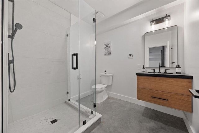 bathroom featuring toilet, a shower stall, vanity, and baseboards