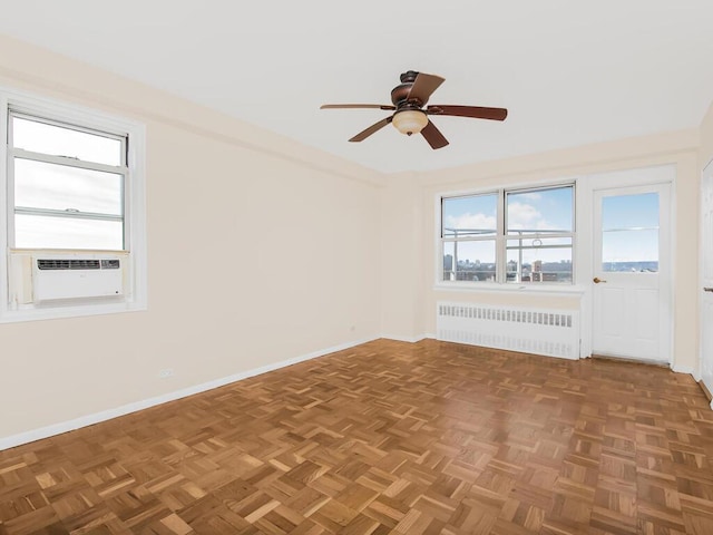 unfurnished room featuring cooling unit, baseboards, ceiling fan, and radiator heating unit