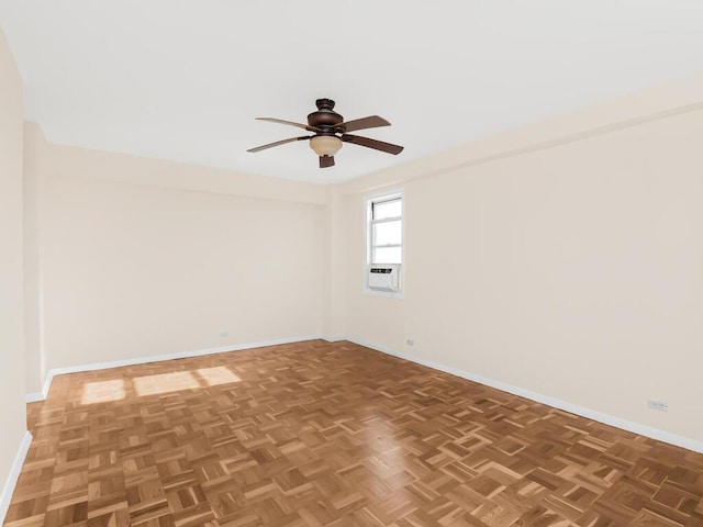 empty room featuring a ceiling fan, cooling unit, and baseboards