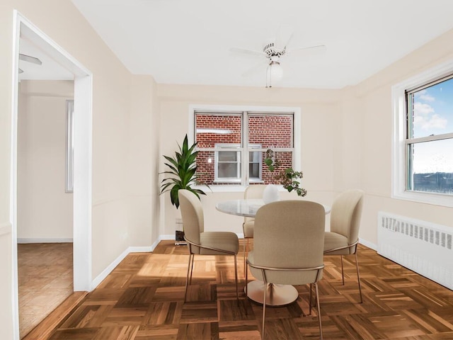 dining room with radiator, baseboards, and a ceiling fan