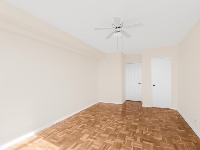 unfurnished room with a ceiling fan and baseboards