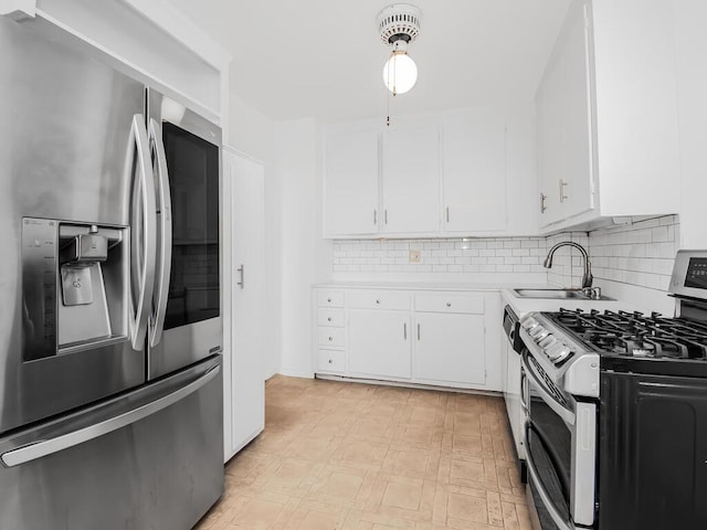 kitchen with white cabinets, appliances with stainless steel finishes, light countertops, light floors, and a sink