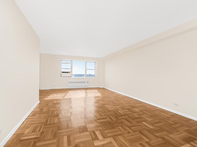 unfurnished room featuring radiator and baseboards