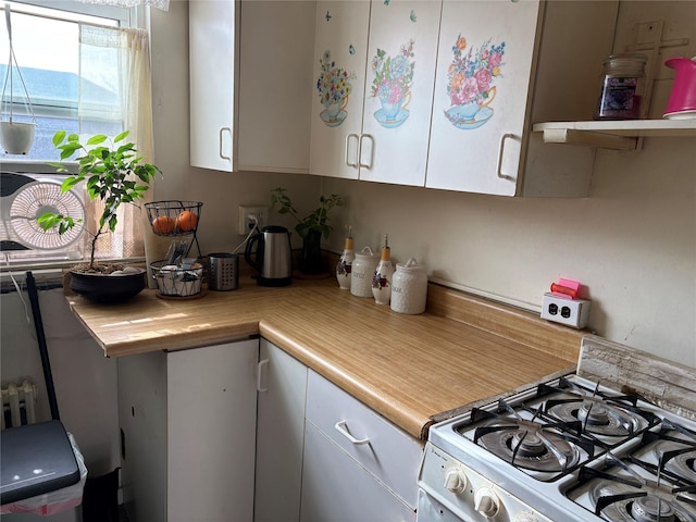 kitchen with white cabinetry and white gas range oven