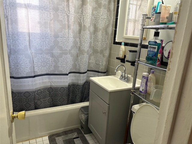 full bathroom with tile patterned flooring, vanity, tile walls, tasteful backsplash, and shower / bath combo