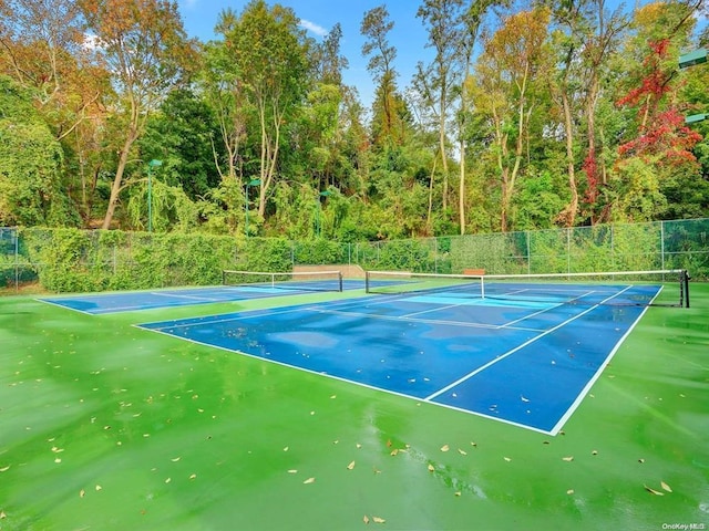 view of tennis court featuring fence