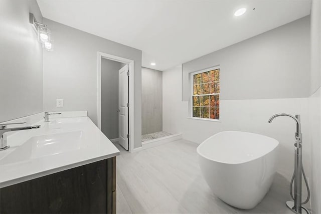 full bath with double vanity, a soaking tub, a sink, and a shower stall