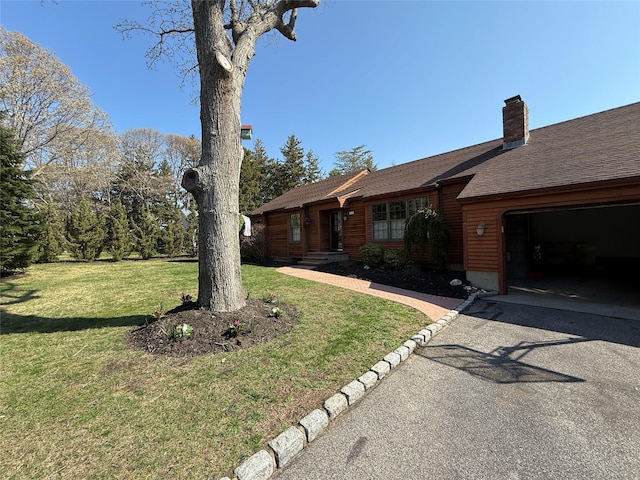 515 Corey Creek Ln, Southold, NY 11971 - single story home with a front lawn, a garage, a shingled roof, driveway, and a chimney