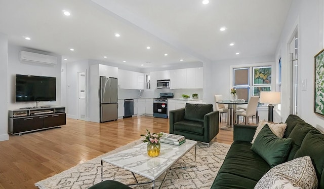 living area featuring light wood-type flooring, an AC wall unit, and recessed lighting