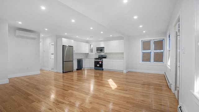 unfurnished living room featuring recessed lighting, a wall mounted air conditioner, light wood-style flooring, and baseboard heating