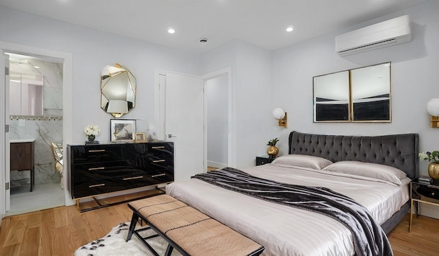 bedroom with recessed lighting, ensuite bathroom, light wood finished floors, and a wall mounted AC