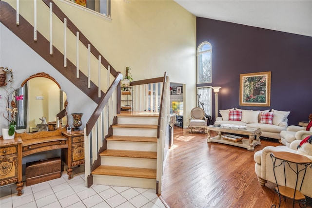 stairs featuring high vaulted ceiling and wood finished floors