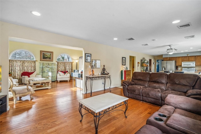 living room featuring light wood-style flooring, visible vents, and recessed lighting