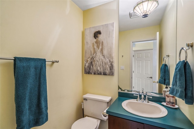 half bathroom featuring toilet, visible vents, and vanity