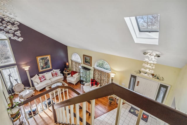 living room with vaulted ceiling with skylight and wood finished floors