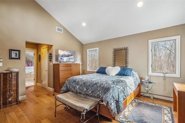 bedroom with lofted ceiling, visible vents, light wood-style flooring, a baseboard heating unit, and multiple windows