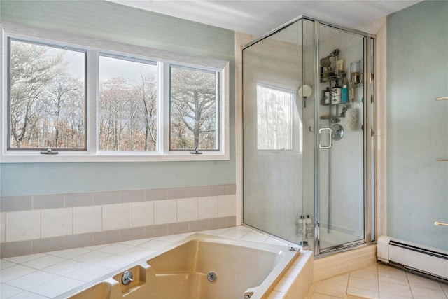 bathroom with a tub with jets, a baseboard radiator, and tile patterned flooring