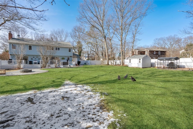 view of yard with an outbuilding, a fenced backyard, a patio, and a shed