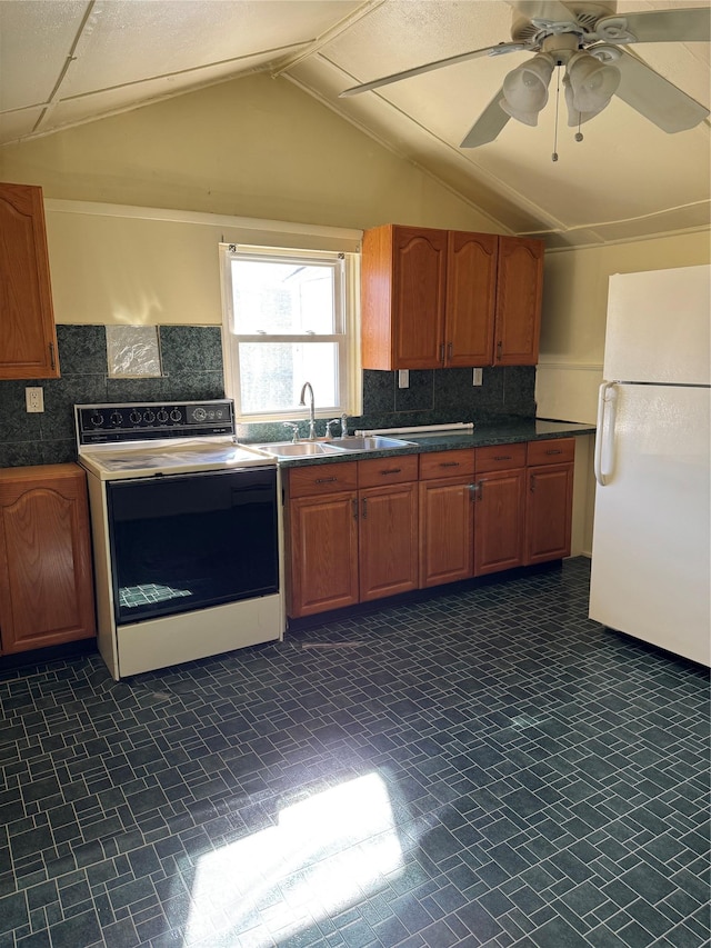 kitchen featuring a sink, electric stove, freestanding refrigerator, brown cabinets, and dark countertops