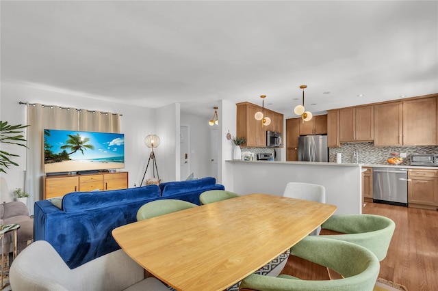 dining space featuring light wood-style flooring and a toaster