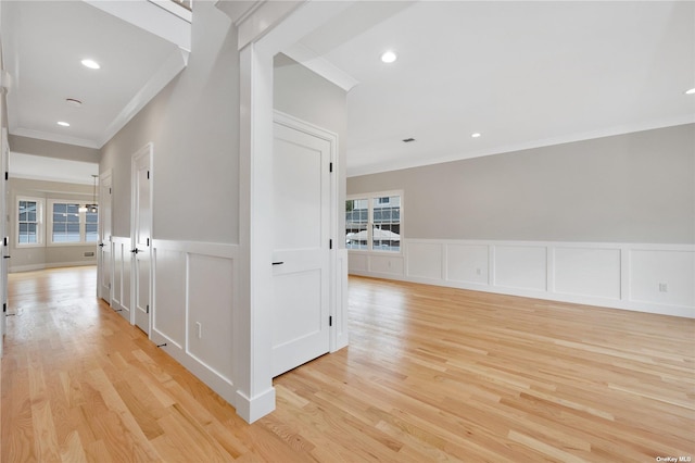 corridor featuring light wood-type flooring, a healthy amount of sunlight, crown molding, and recessed lighting