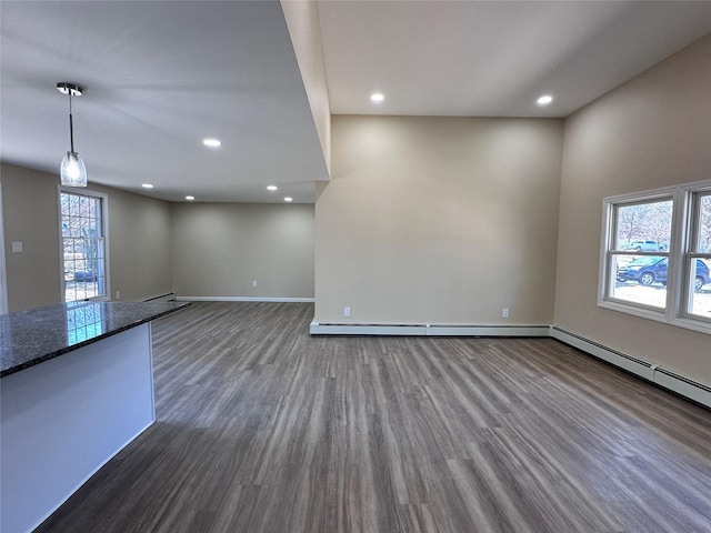 interior space with baseboards, a baseboard heating unit, dark wood finished floors, and recessed lighting