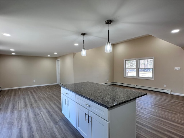 kitchen featuring white cabinets, dark stone counters, open floor plan, baseboard heating, and pendant lighting