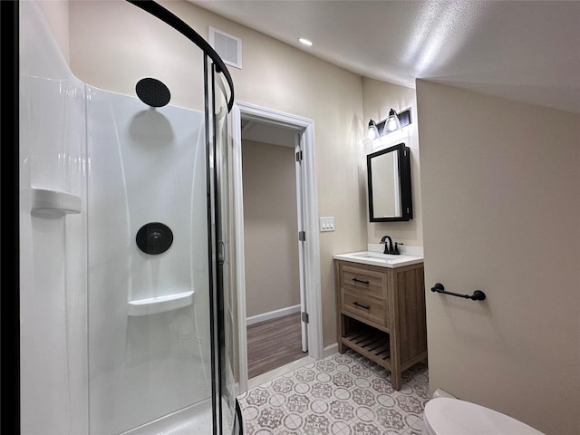 bathroom featuring a walk in shower, toilet, vanity, and visible vents