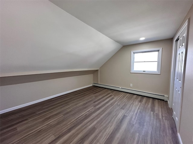 additional living space featuring dark wood-style floors, a baseboard radiator, lofted ceiling, and baseboards