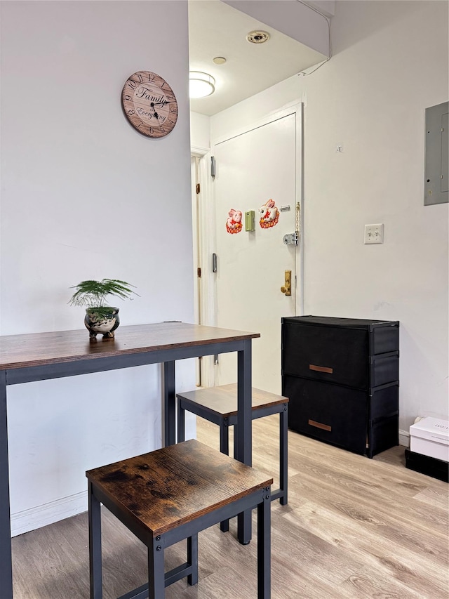 dining space featuring electric panel and light wood finished floors