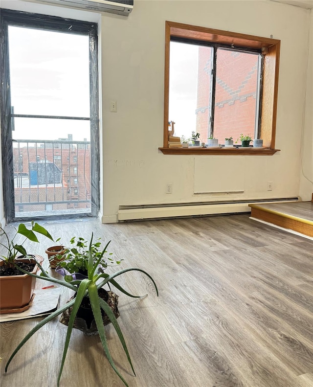 spare room with a baseboard radiator and wood finished floors