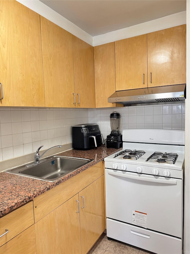 kitchen featuring tasteful backsplash, extractor fan, a sink, and white range with gas stovetop