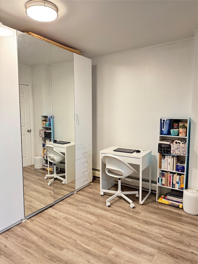 office space with light wood-type flooring and baseboard heating