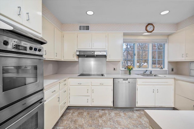 kitchen featuring light countertops, appliances with stainless steel finishes, a sink, and visible vents