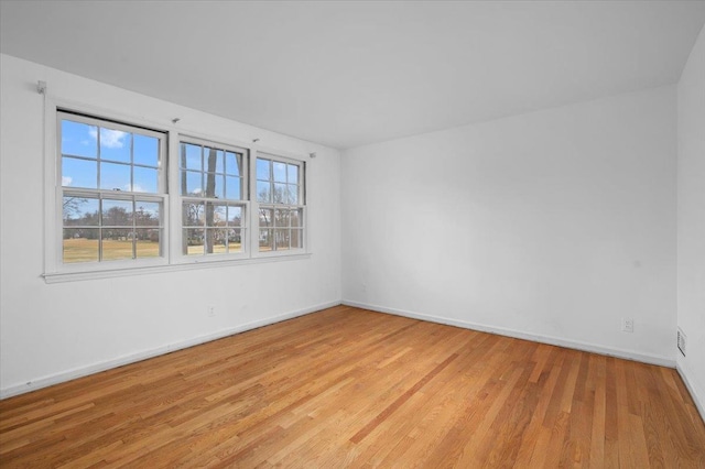 empty room featuring light wood finished floors and baseboards